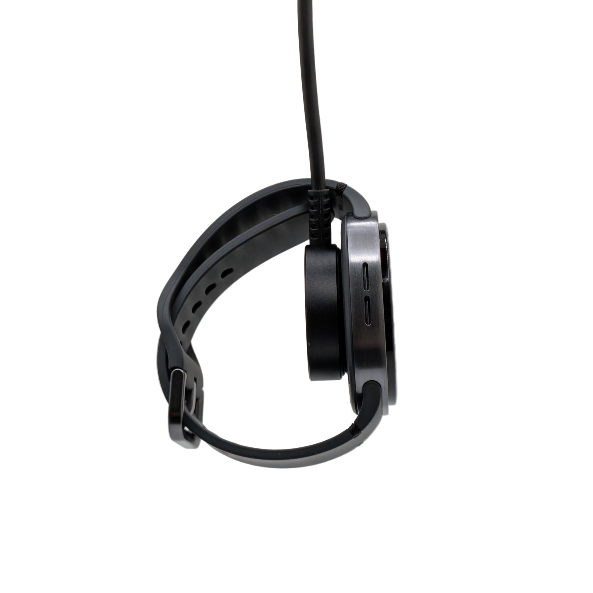 Watch dangling from a charging puck on a white background