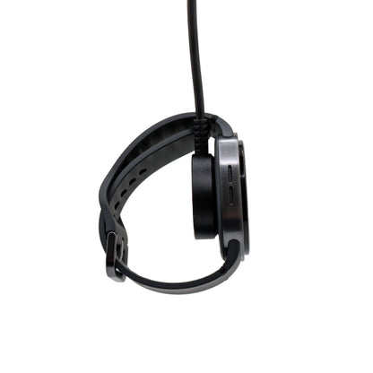 Watch dangling from a charging puck on a white background